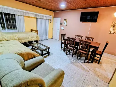 a living room with a couch and a table and chairs at Apart Hotel RITZ in Villa Carlos Paz