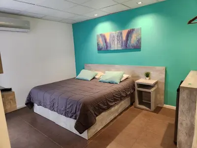 a bedroom with a bed with a blue wall at PH suites in Río Cuarto