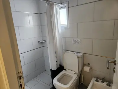 a small bathroom with a toilet and a window at PH suites in Río Cuarto