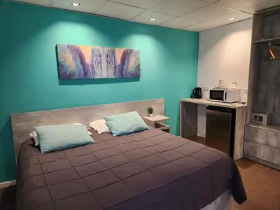 a bedroom with a bed and a microwave on the wall at PH suites in Río Cuarto