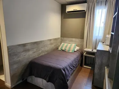 a small bedroom with a bed in a room at PH suites in Río Cuarto