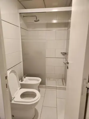 a white bathroom with a toilet and a sink at PH suites in Río Cuarto