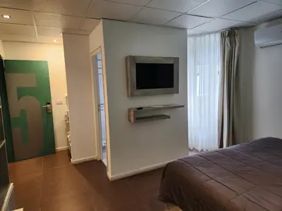 a bedroom with a bed and a tv on a wall at PH suites in Río Cuarto