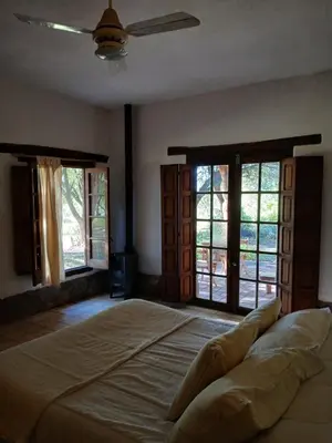 a bedroom with a large bed and two windows at Varuna- en La Casa de Nanda in San Javier