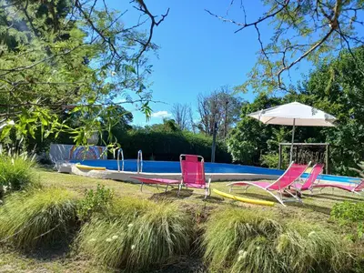 a group of chairs and an umbrella next to a swimming pool at Varuna- en La Casa de Nanda in San Javier