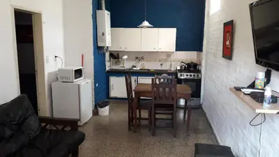 a small kitchen with a table and a refrigerator at Depto Tribunales in Cordoba