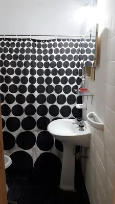 a bathroom with a sink and a black and white patterned wall at Depto Tribunales in Cordoba