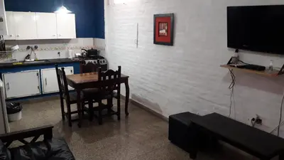 a kitchen with a table and chairs and a tv at Depto Tribunales in Cordoba