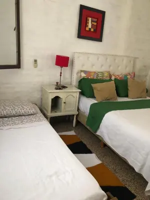 a bedroom with two beds and a lamp on a night stand at Depto Tribunales in Cordoba