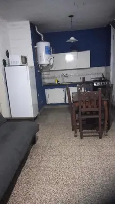 a small kitchen with a table and a refrigerator at Depto Tribunales in Cordoba