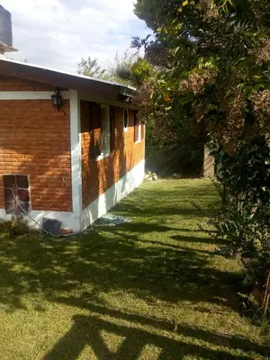 a house with a grass yard next to a building at El Faro in Potrero de Garay