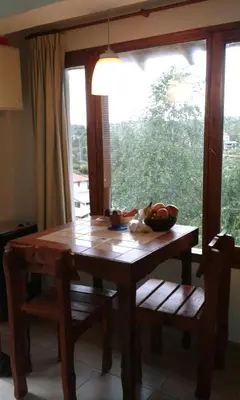 a wooden table and chairs with a window in a kitchen at VISTA FRANCA in La Cumbrecita