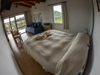a bedroom with a large bed in a room with a window at VISTA FRANCA in La Cumbrecita