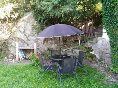 a table and chairs with an umbrella in the grass at VISTA FRANCA in La Cumbrecita