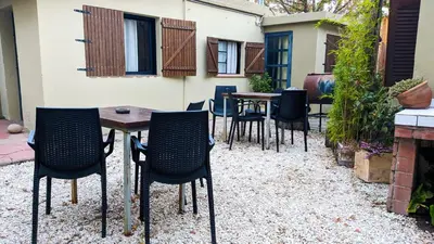 a patio with tables and chairs in a backyard at Benvinguts Casa y Apartamentos de 1 a 12 personas Pleno Centro Santa Rosa de Calamuchita in Santa Rosa de Calamuchita