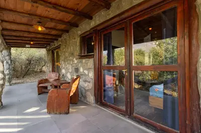 a screened porch with a table and a window at ASM CABAÑAS XIII in Merlo