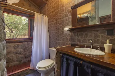 a bathroom with a sink and a toilet and a window at ASM CABAÑAS XIII in Merlo