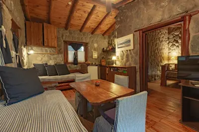 a living room with a wooden table and chairs at ASM CABAÑAS XIII in Merlo