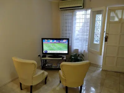 a living room with two chairs and a television at CERRO CHICO APART in Cordoba