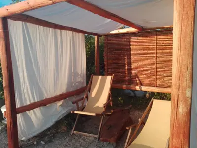 a porch with a chair and a tent at Refugio: El Llamado in Villa de Las Rosas