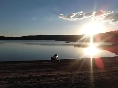 a boat sitting on the shore of a body of water at Refugio: El Llamado in Villa de Las Rosas
