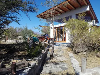a house being constructed with a stone retaining wall at Refugio: El Llamado in Villa de Las Rosas
