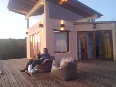 a man sitting in a chair on a deck at Refugio: El Llamado in Villa de Las Rosas