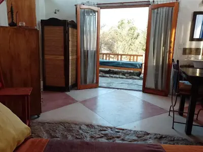 a bedroom with a door open to a patio at Refugio: El Llamado in Villa de Las Rosas