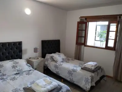 a bedroom with two beds and a window at Casa confortable in Cordoba