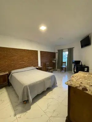 a bedroom with a bed and a brick wall at Departamentos Mina Clavero in Mina Clavero