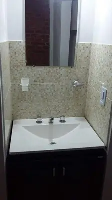 a bathroom with a white sink and a mirror at Departamentos Mina Clavero in Mina Clavero