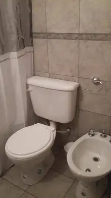 a bathroom with a white toilet and a sink at Departamentos Mina Clavero in Mina Clavero