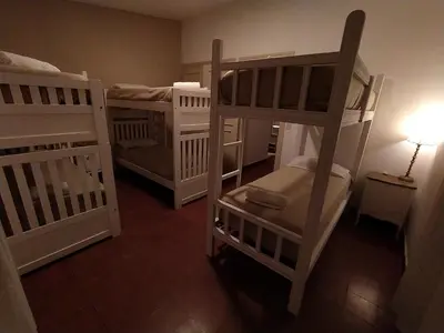a room with three bunk beds and a lamp at Casa de Montaña in Cordoba