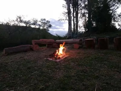 a fire pit in the grass with a couch at Casa de Montaña in Cordoba
