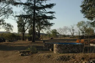 a picnic table in a field with trees in the background at Casa de Montaña in Cordoba