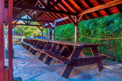 a row of wooden benches sitting under a roof at Hotel Villa Sol in Merlo
