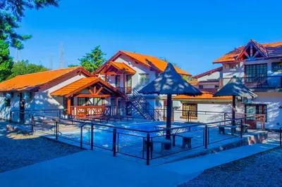a house with a table and umbrellas in front of it at Hotel Villa Sol in Merlo