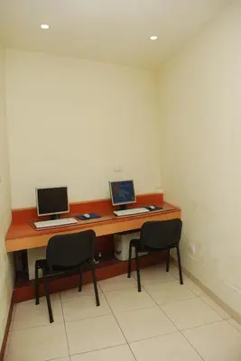 a desk with two computers on it with two chairs at Hotel Gran Crisol in Cordoba