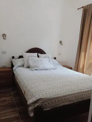 a bedroom with a bed with white sheets and pillows at Casa Roma in Villa Carlos Paz