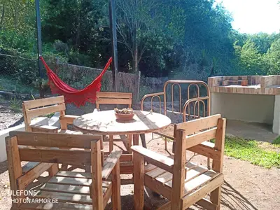 a table and two chairs and a hammock in a yard at Casa Roma in Villa Carlos Paz