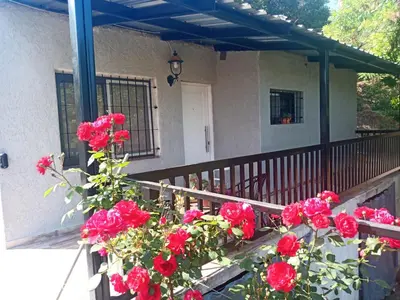 a balcony with red roses in front of a house at Casa Roma in Villa Carlos Paz