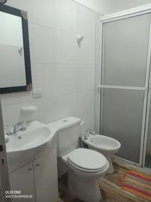 a bathroom with a toilet and a sink and a shower at Casa Roma in Villa Carlos Paz