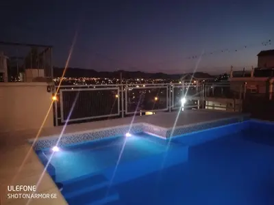 a swimming pool on the roof of a building at night at Casa Roma in Villa Carlos Paz