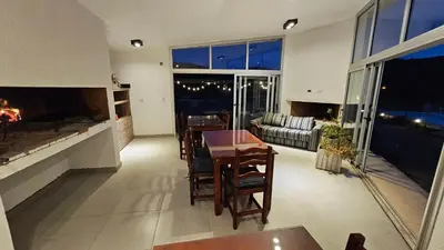 a living room with a table and a fireplace at Los Cóndores Aparts. in Villa General Belgrano