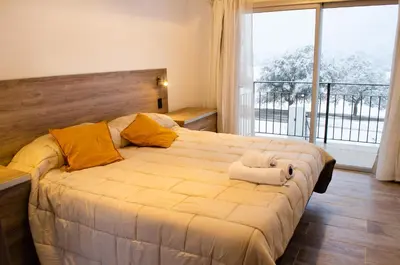 a bedroom with a large bed with a large window at Los Cóndores Aparts. in Villa General Belgrano
