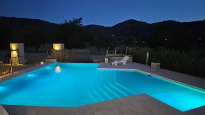 a swimming pool lit up at night at Los Cóndores Aparts. in Villa General Belgrano