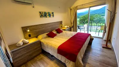 a bedroom with a bed and a large window at Los Cóndores Aparts. in Villa General Belgrano