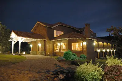 a large house with lights in the night at La Barraca Resort in Merlo