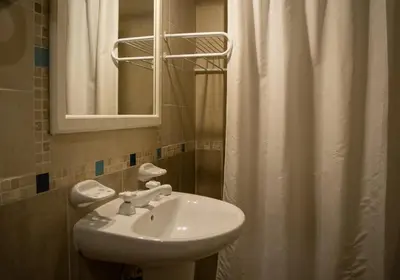 a bathroom with a sink and a shower curtain at La Barraca Resort in Merlo