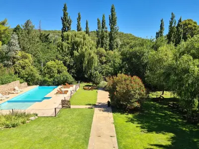 a garden with a swimming pool and trees at La Barraca Resort in Merlo